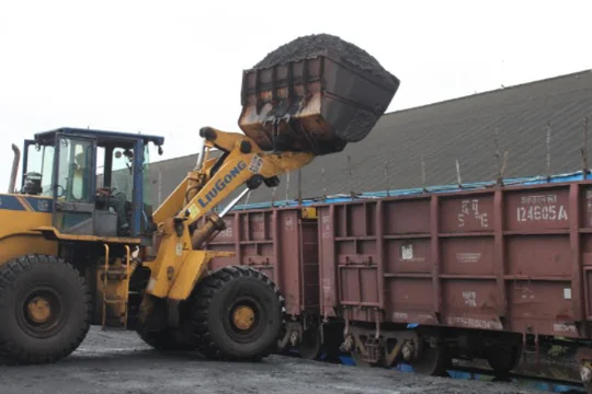 Loader transferring material into a railway wagon
