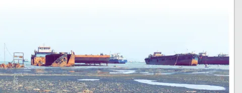 Vessels resting at a dry dock beside the water